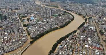 A river overflows in southern China, stranding people and turning streets into canals