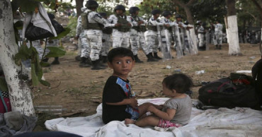 100s in river 'no-man's land' after Mexico troops block way