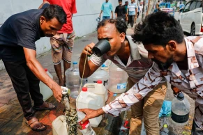 Seeking respite from the scorching heat at a public water line