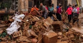 Mud-caked volunteers clean flood debris in a Spanish town as authorities struggle to respond