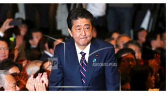 Japan's Abe re-elected as party head, to stay on as PM